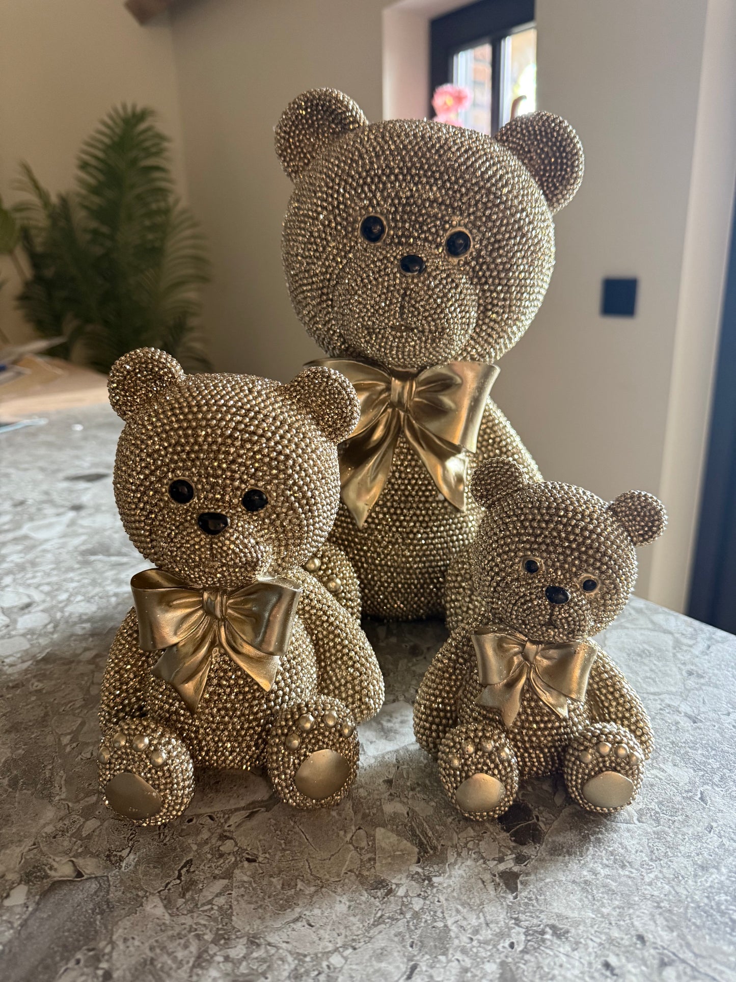 Gouden teddybeer beeld met strik en kralenstructuu