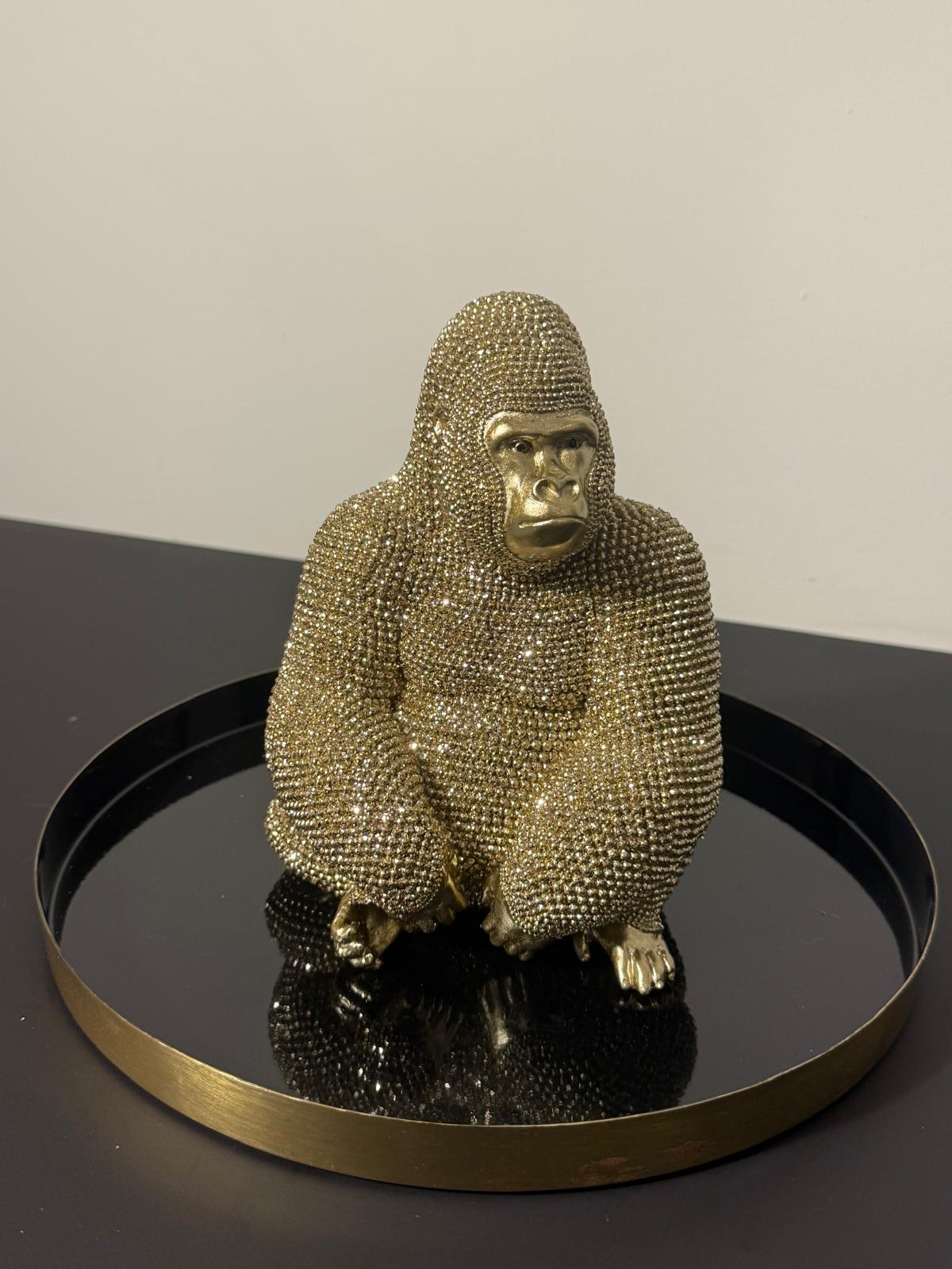 Zittend gouden gorilla beeld van polyresin met gedetailleerde kralenstructuur en glanzende goudkleurige afwerking, circa 21 x 15 x 19 cm.