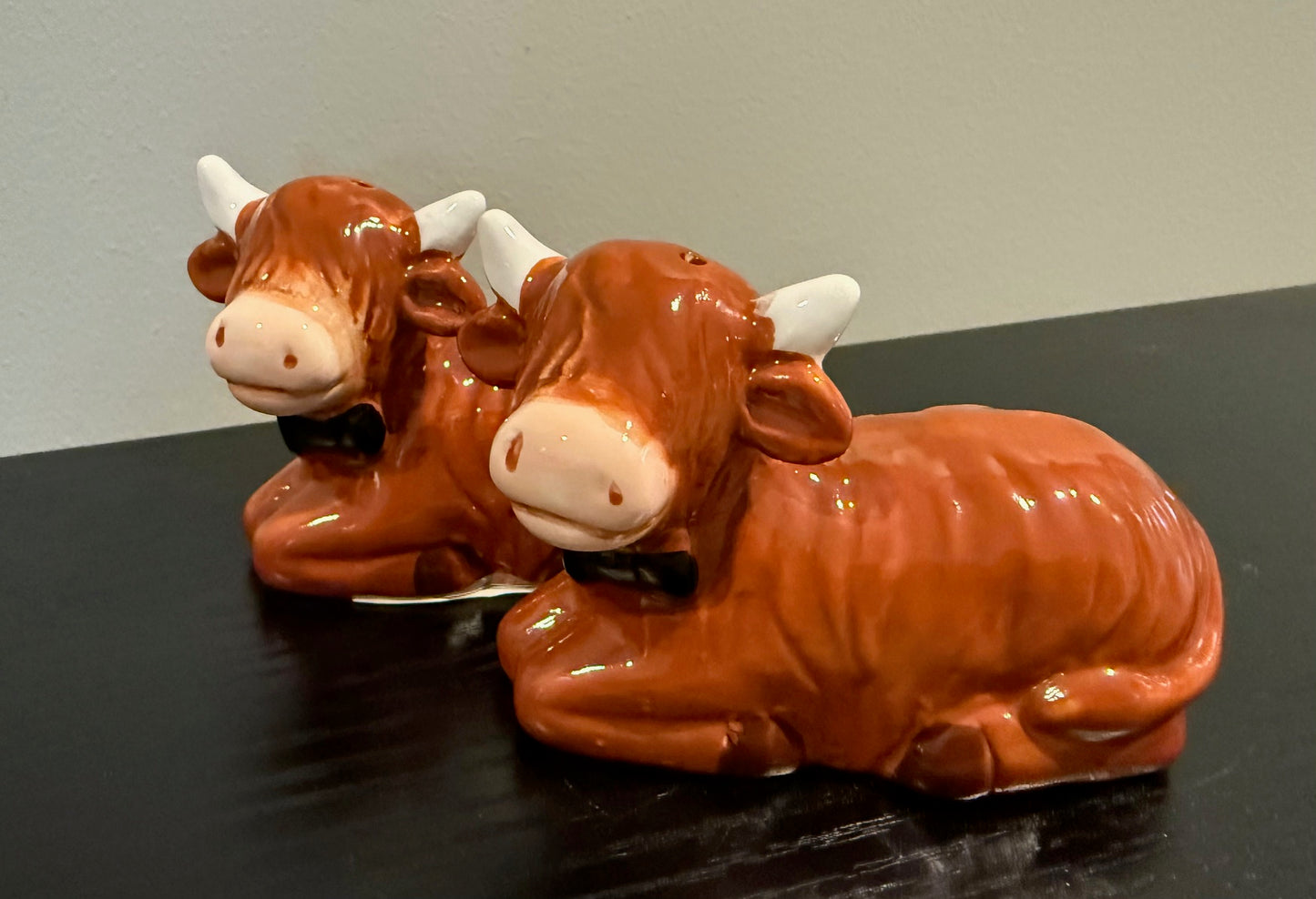 Keramiek peper- en zoutstel in de vorm van liggende Schotse Hooglanders met strik – 8x3,5x5,5 cm