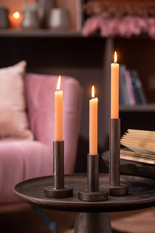 set van 3 donkerbruine metalen kandelaars met kaarsen op tafel