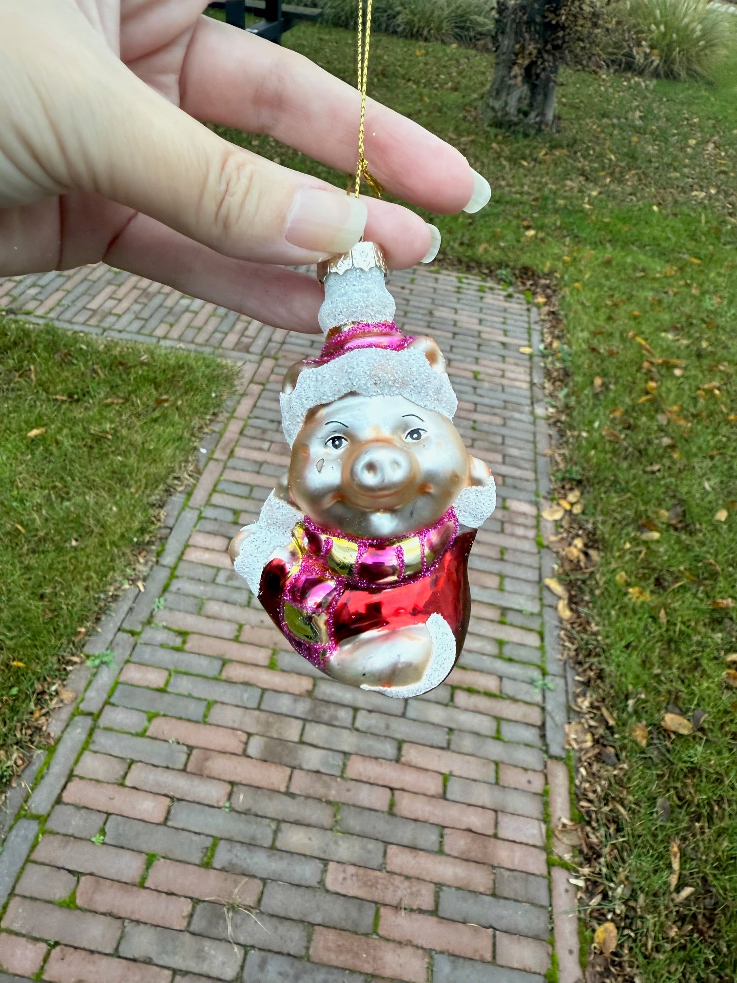 Handbeschilderde glazen kersthanger in de vorm van een varkentje met rode jas en glitterdetails – 10 cm hoog