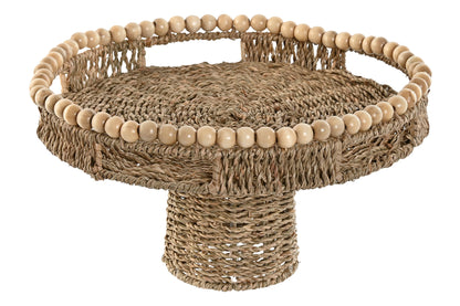 Decoratief rond zeegras plateau op verhoogde voet met houten kralenrand en handgrepen voor een Bali, boho en coastal interieur.