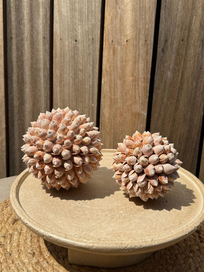 Handgemaakte Bola Buteng schelpenbollen van natuurlijke schelpen in warme zalm-, beige- en crèmetinten, set van twee uit Indonesië.