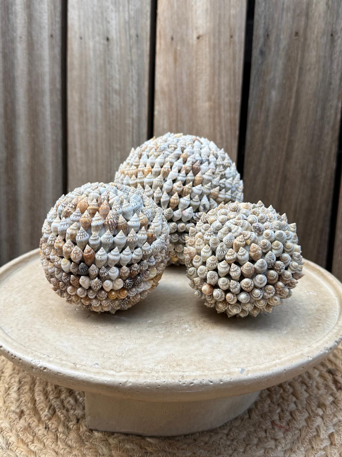 Set van drie handgemaakte schelpenbollen uit Indonesië in natuurlijke wit-, crème- en zandtinten met diameters van 7, 9 en 11 cm