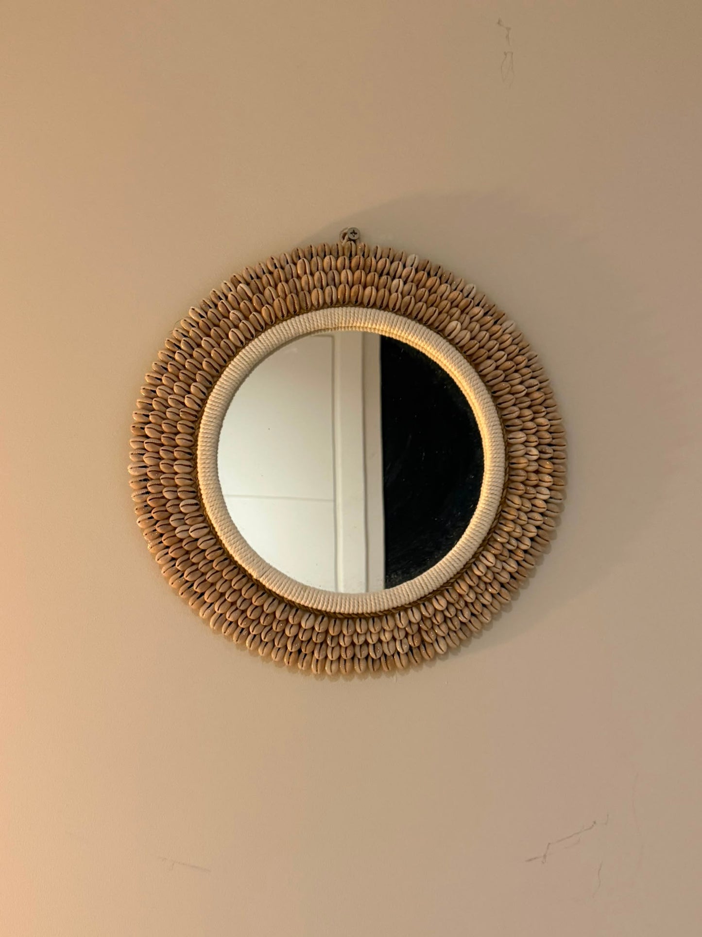 Handgemaakte ronde kauri schelpen spiegel uit Bali naturel Ø 30 cm aan de muur