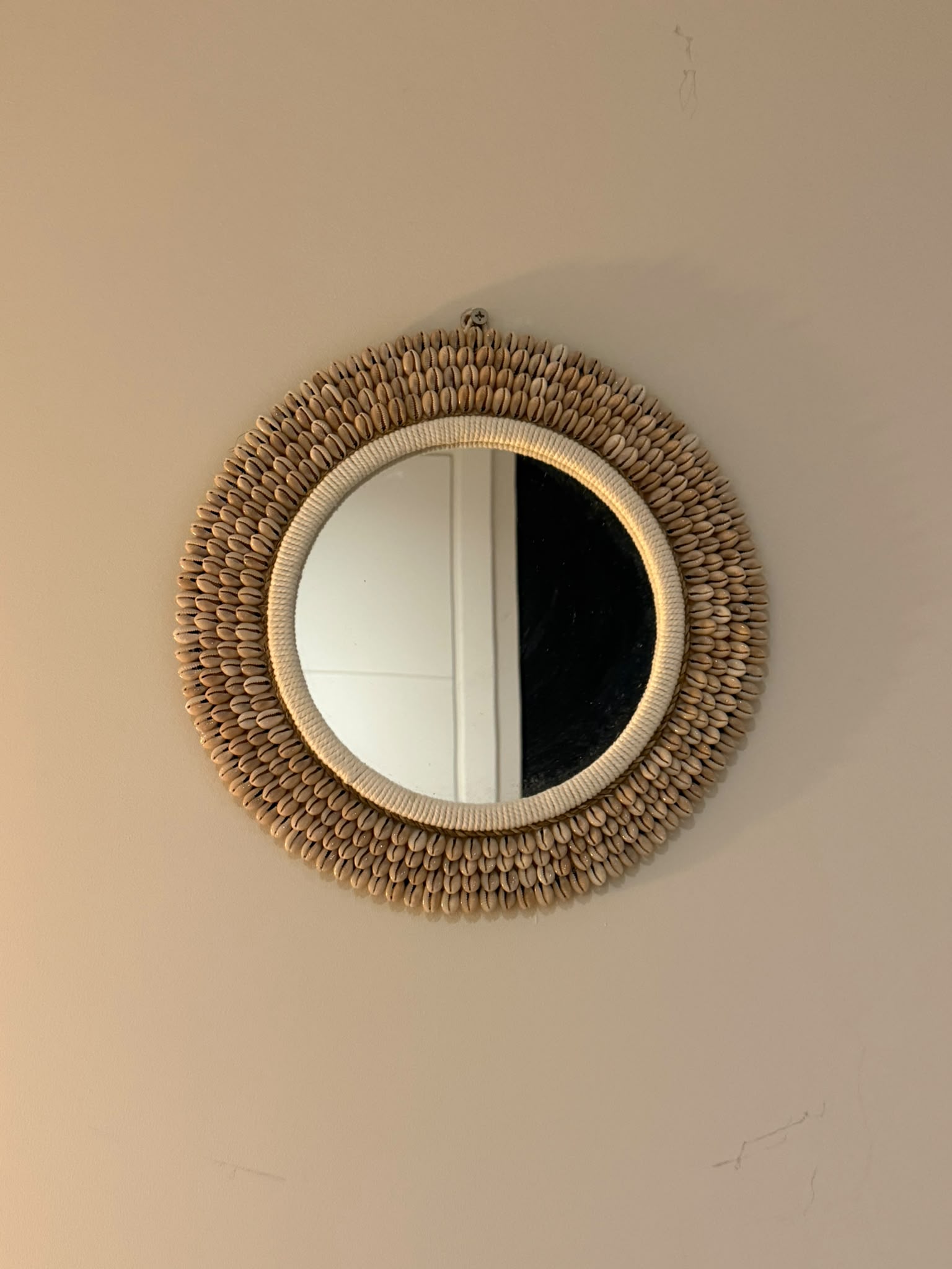 Handgemaakte ronde kauri schelpen spiegel uit Bali naturel Ø 30 cm aan de muur