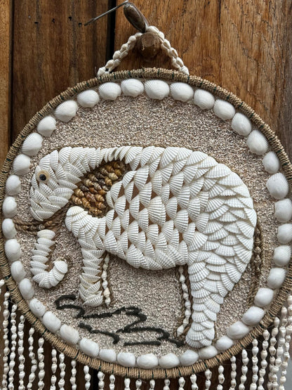 Detail van handgemaakte olifant wanddecoratie met witte natuurlijke schelpen